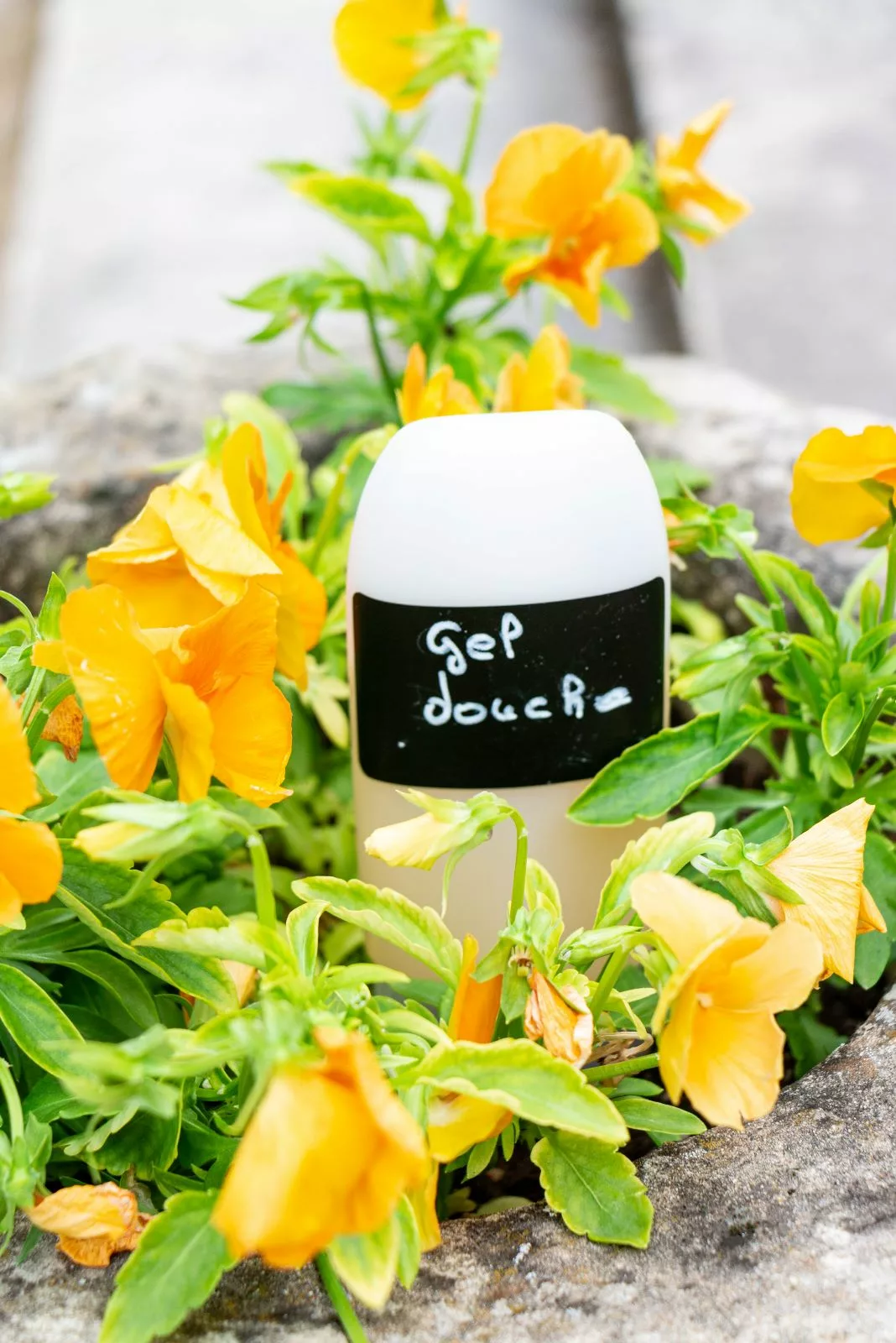 Tube de gel douche sur fond fleuri