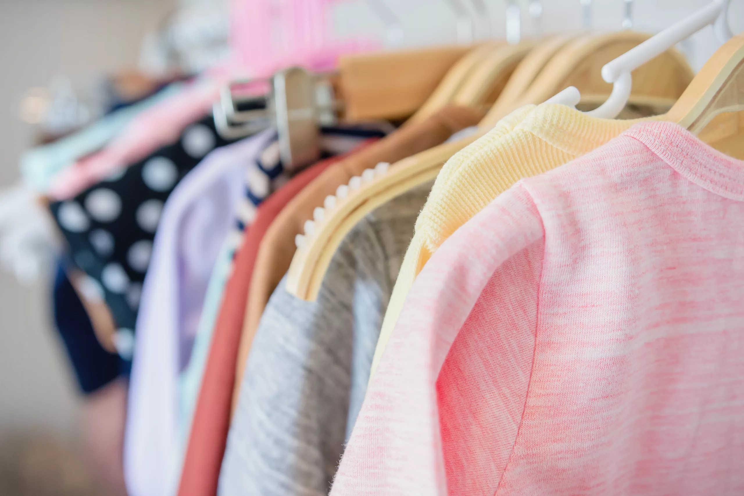 Un portant avec de nombreux vêtements sur cintres