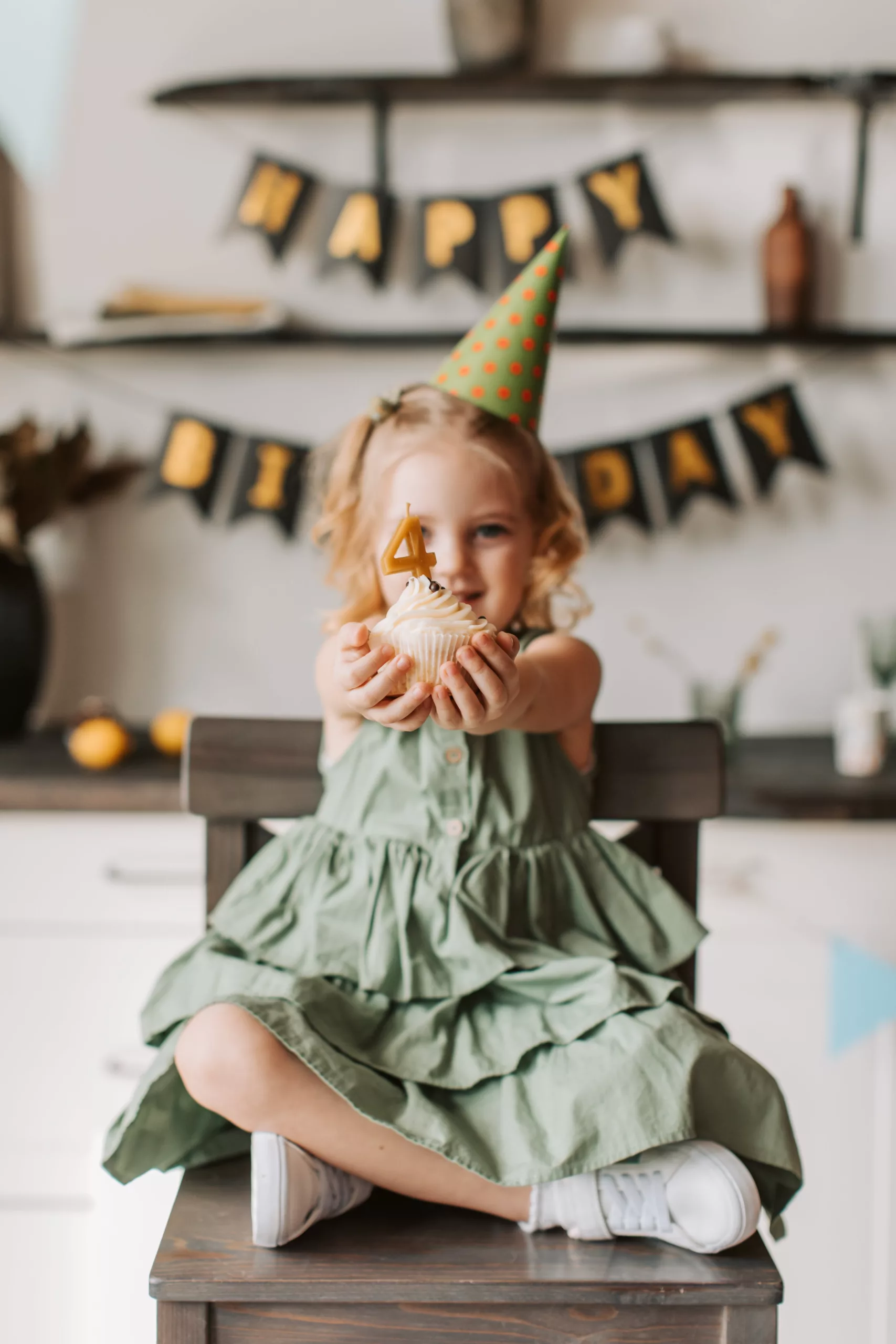 une petite fille tend un gâteau d'anniversaire pour ses 4 ans.