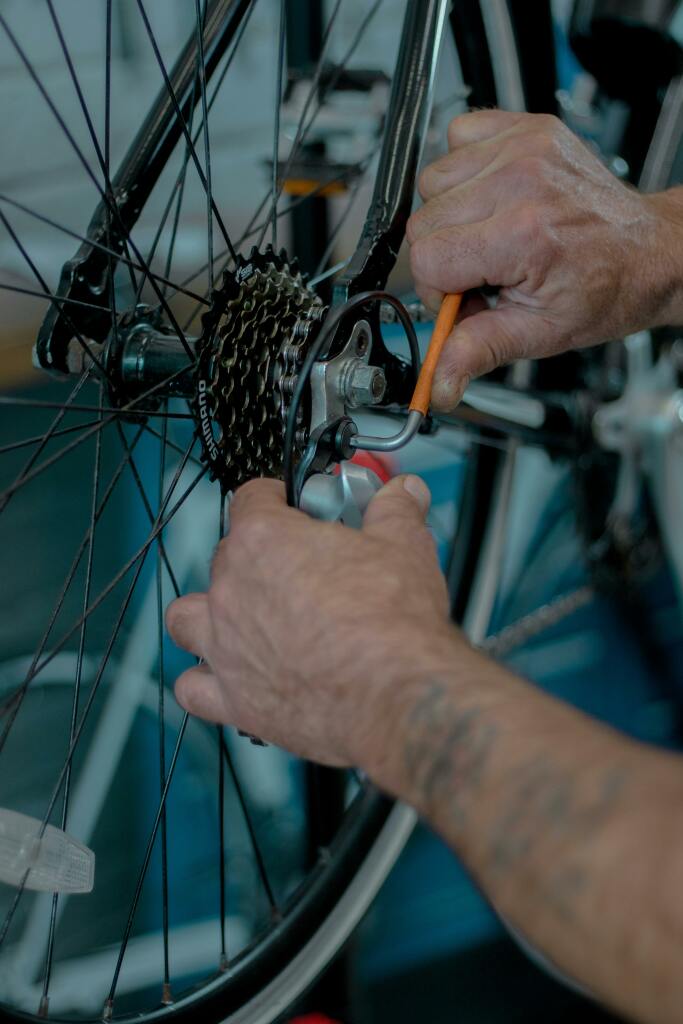 Des mains réparent une chaîne de vélo.