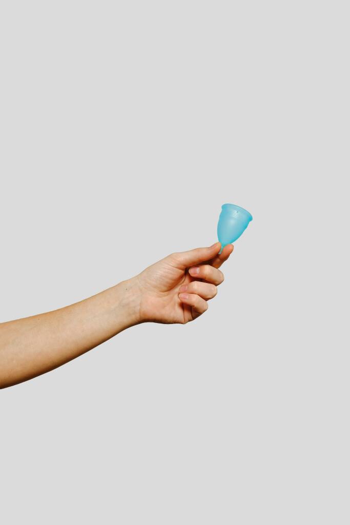 Une main tend une cup bleue.