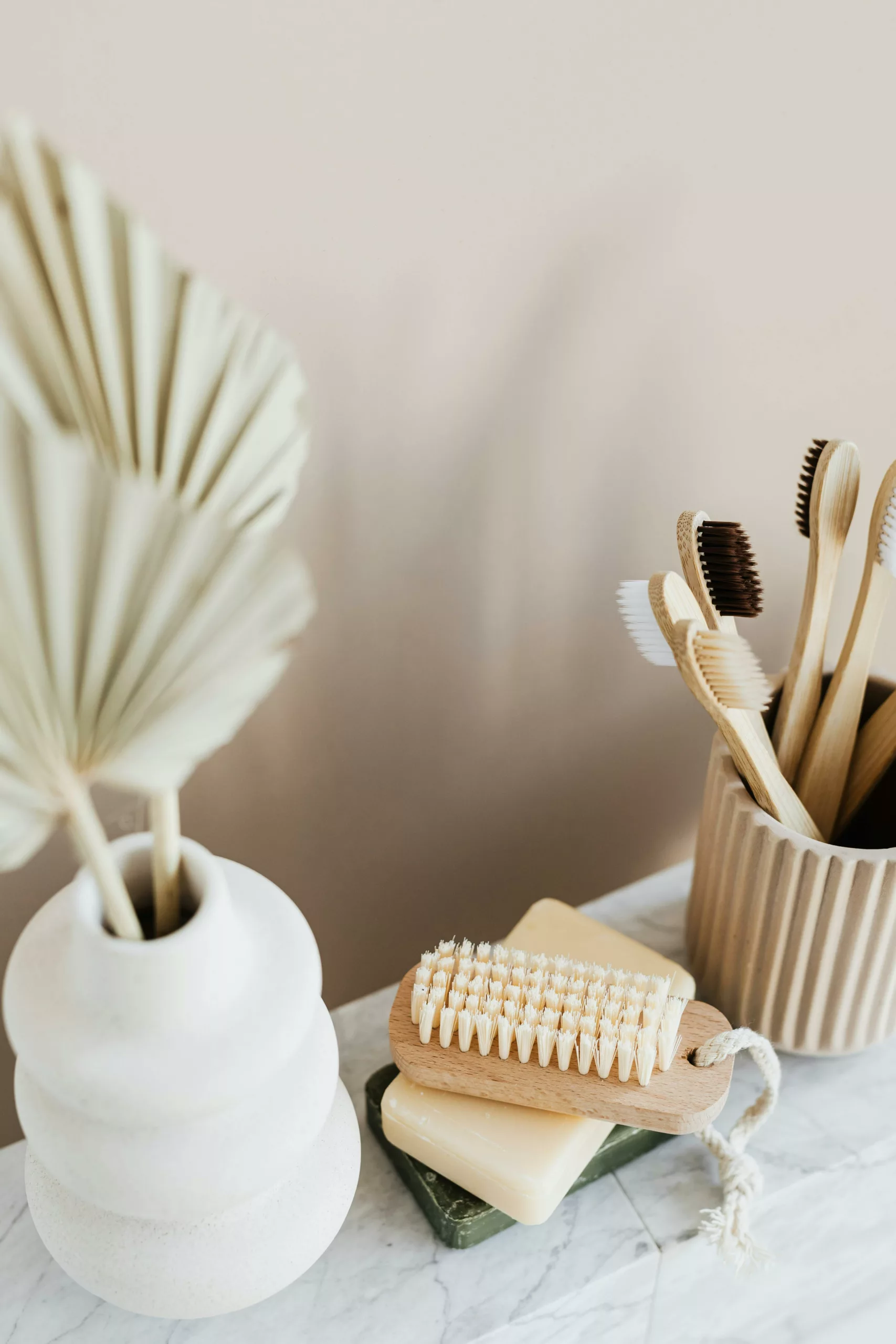 Une salle de bain zero-déchet. On y voit un vase, une brosse, des savons et des brosses à dents en bois
