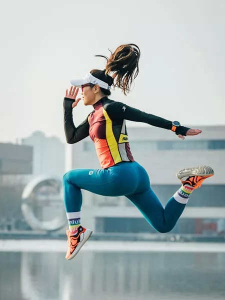 Une sportive court et saute, habillée en tenue de sport.