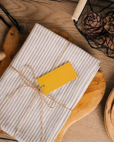 Cadeau de Noël zéro-déchet, emballé dans du tissu avec étiquette carton.